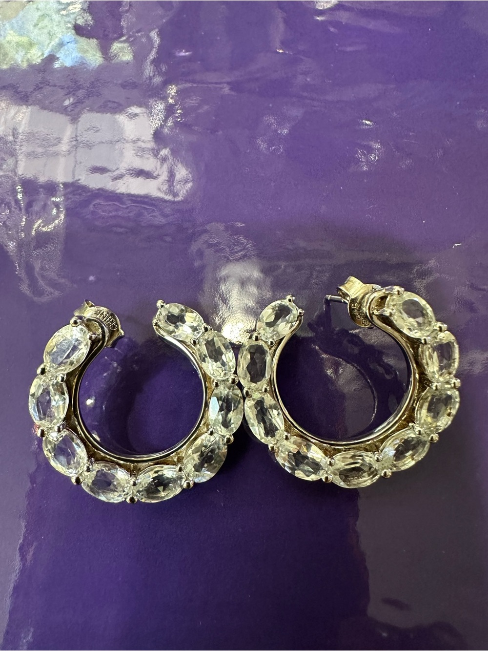 Silver with Rhodium plated forward facing hoops. White Topaz oval  stone